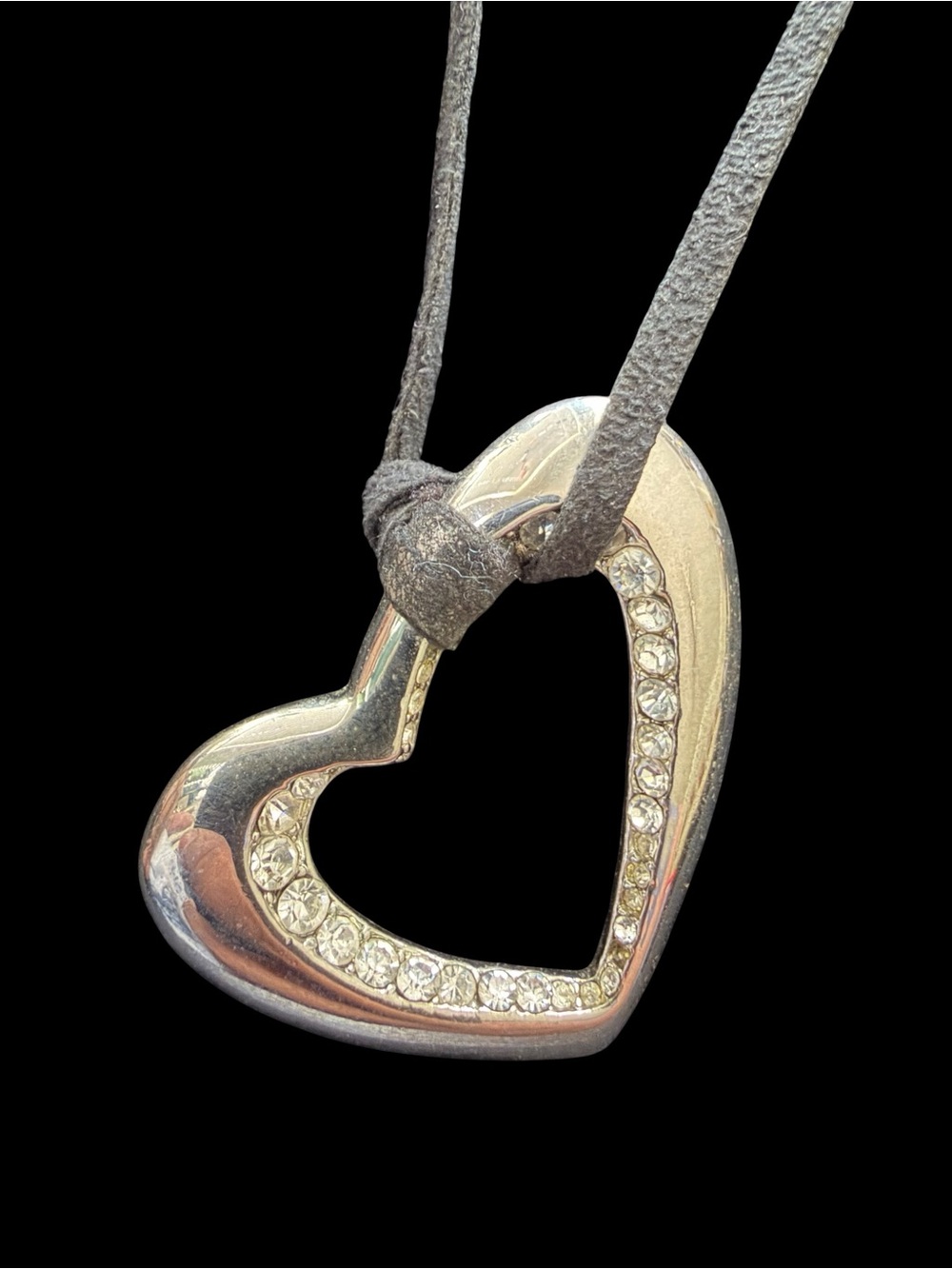 Necklace with gray cord tied around the large rhinestone heart shaped pendant